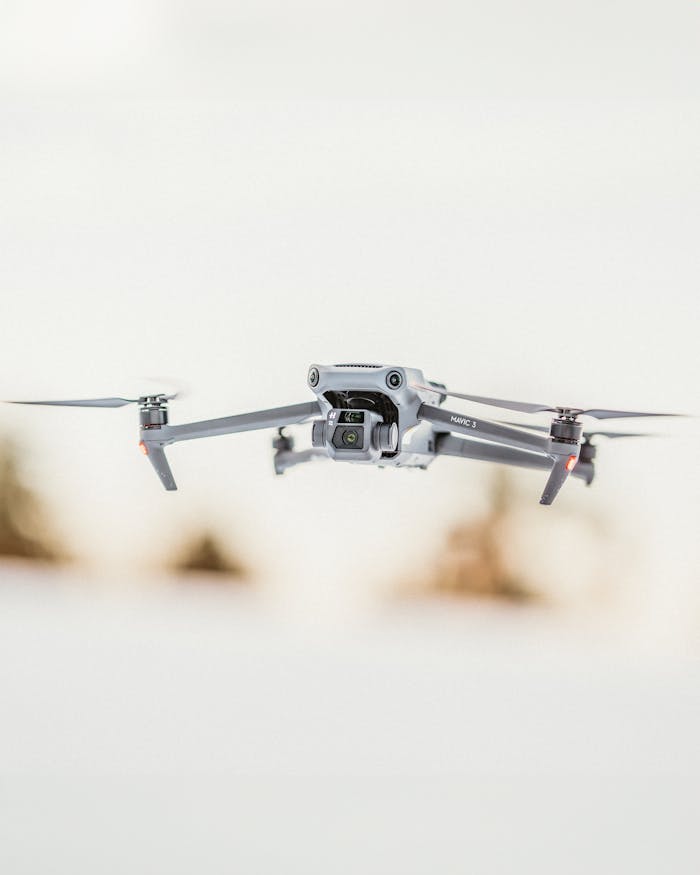 Close-up of a modern drone flying with a blurred background, showcasing advanced technology.
